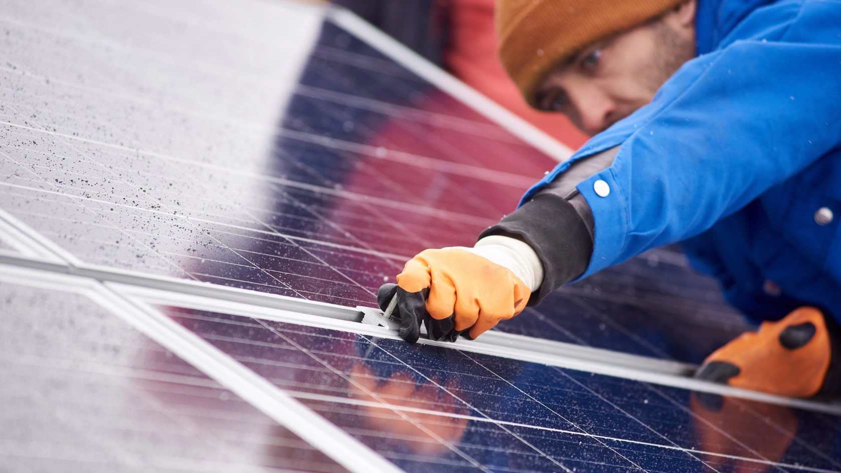 Ein Mann befestigt eine Platte Solarzellen.