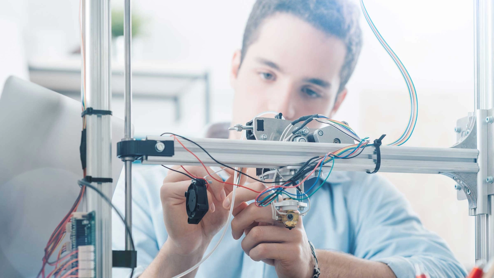 Ein Auszubildender arbeitet an einem 3D-Drucker