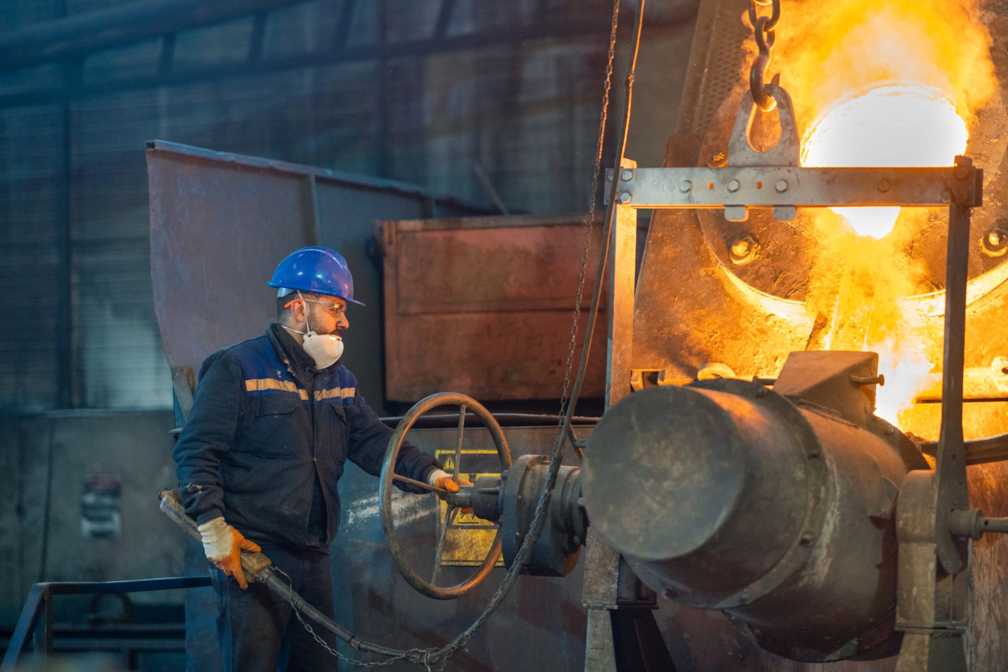 Stahlarbeiter kontrolliert heißen Metallguss