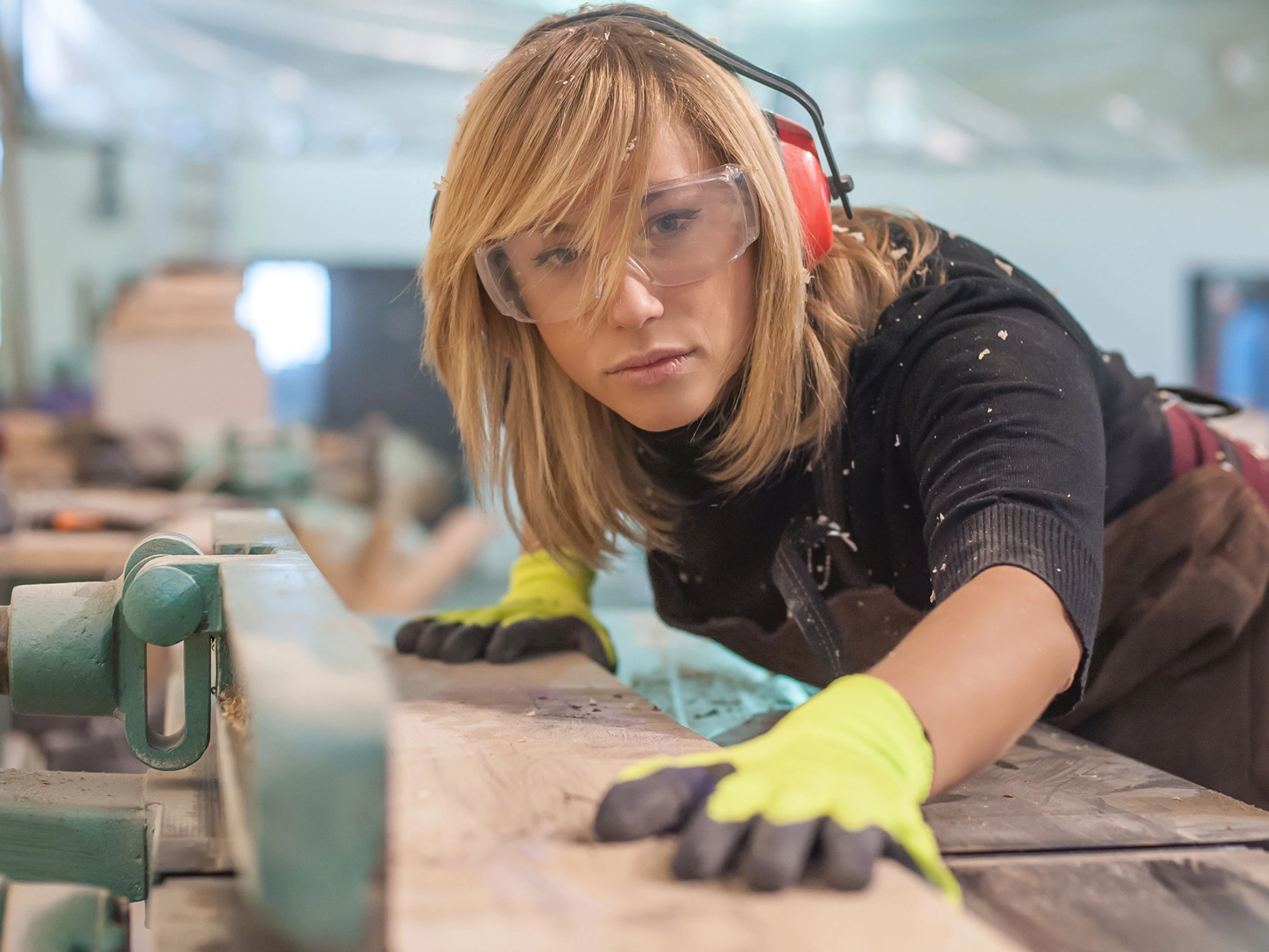 Schreinerin arbeitet an einer Maschine