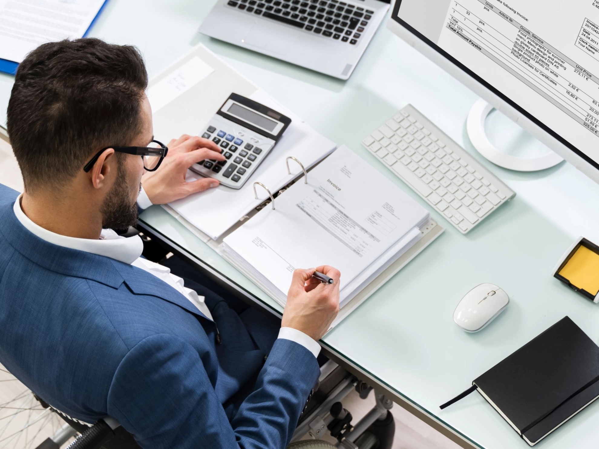 Mann im Rollstuhl arbeitet am Schreibtisch