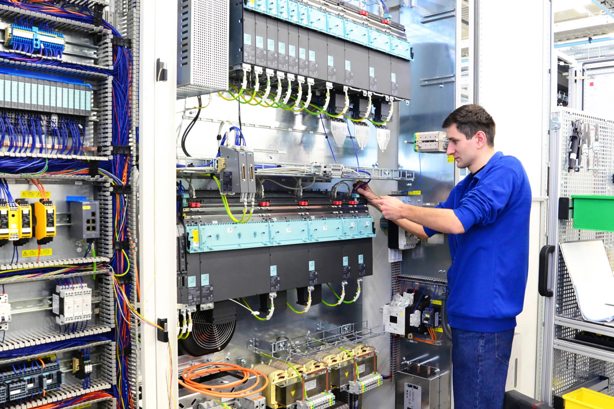Ein junger Mann in der Produktion von Schaltschränken für Industrieanlagen.