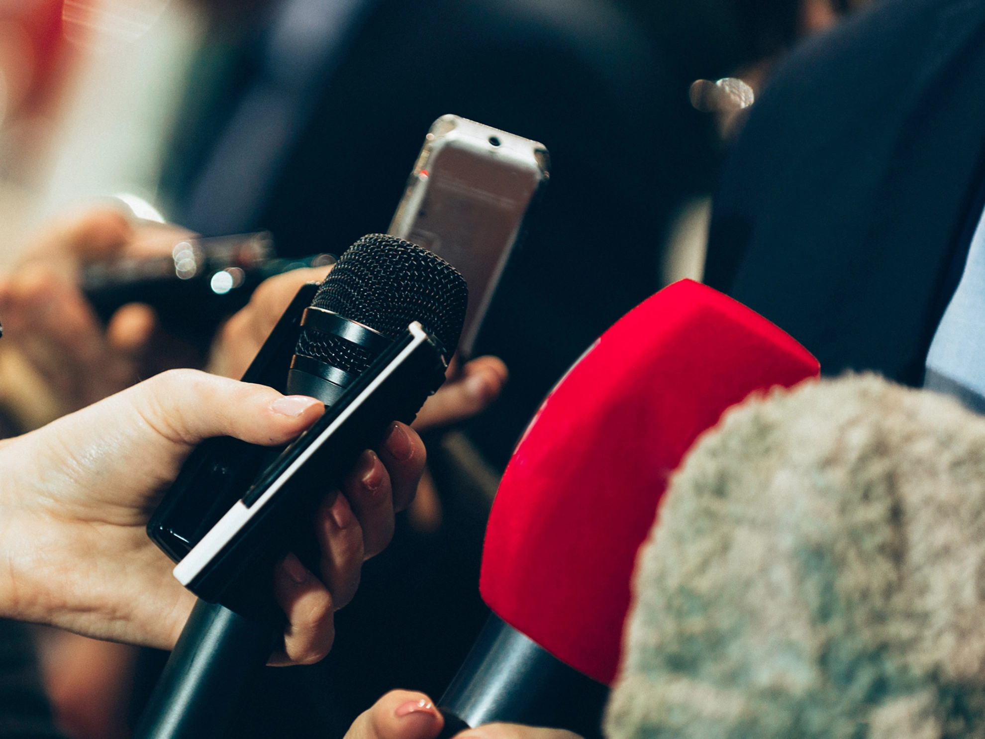 Mann wird bei einem Pressetermin interviewt