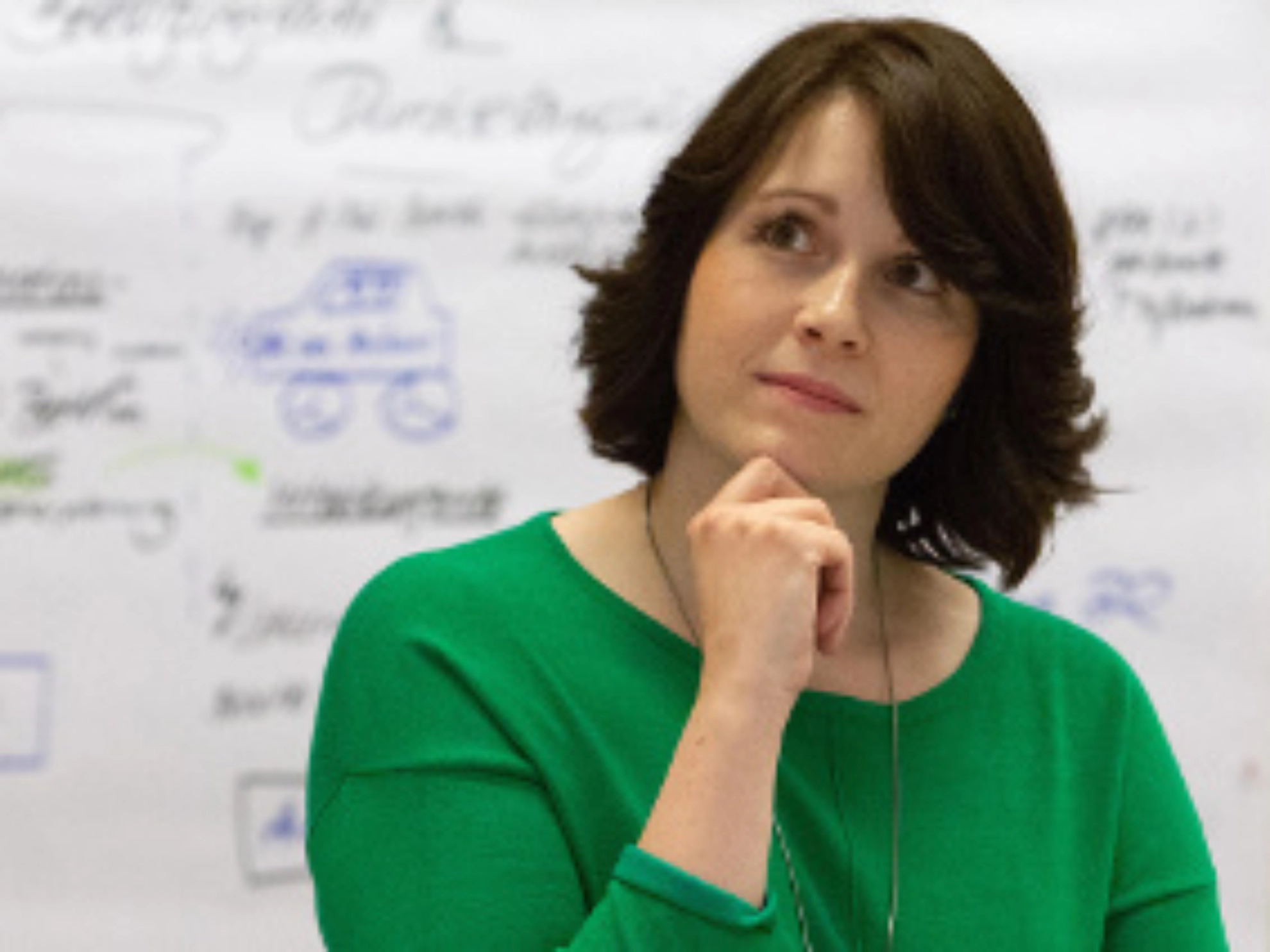 Eine nachdenklich blickende Frau in einem Seminar.