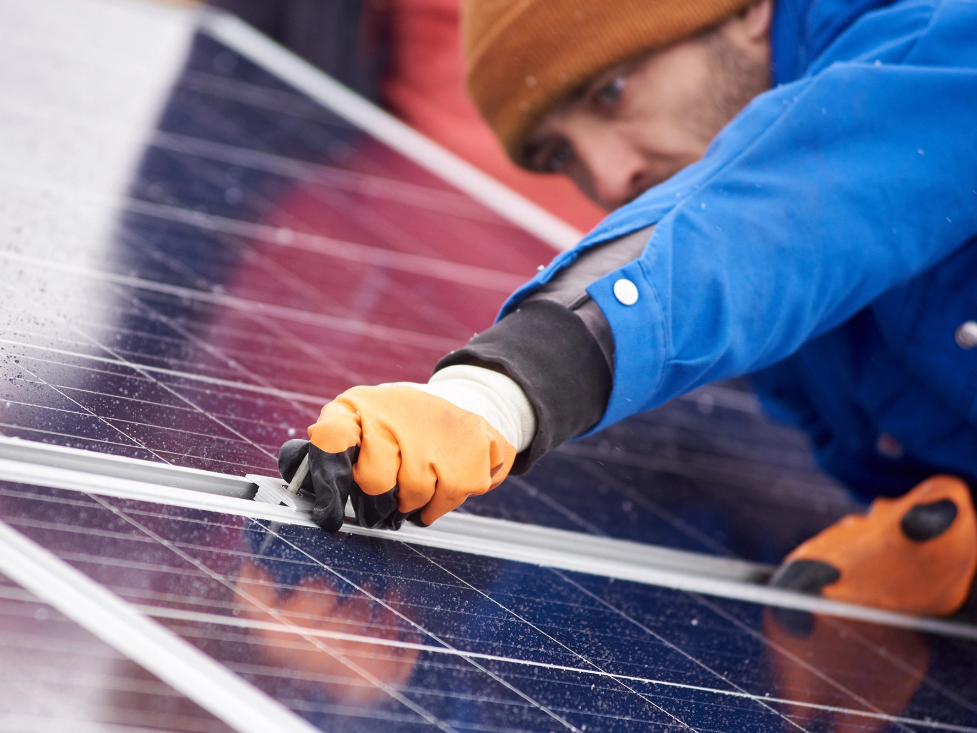 Ein Mann befestigt eine Platte Solarzellen.
