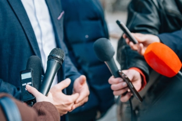Ein Politiker hält auf einer Pressekonferenz ein Interview