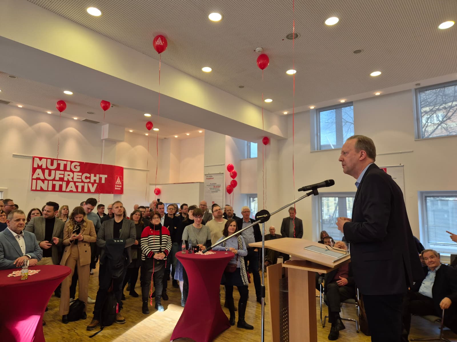 Bild des Neujahrsempfanges 2026 der IG Metall Bremen. Zu sehen ist der Redner Tom Krebs und die Zuschauer.